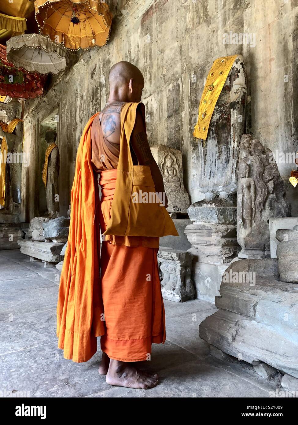 Un monaco silenziosamente pregando in Angkor Wat, Siem Reap, Cambogia. Foto Stock