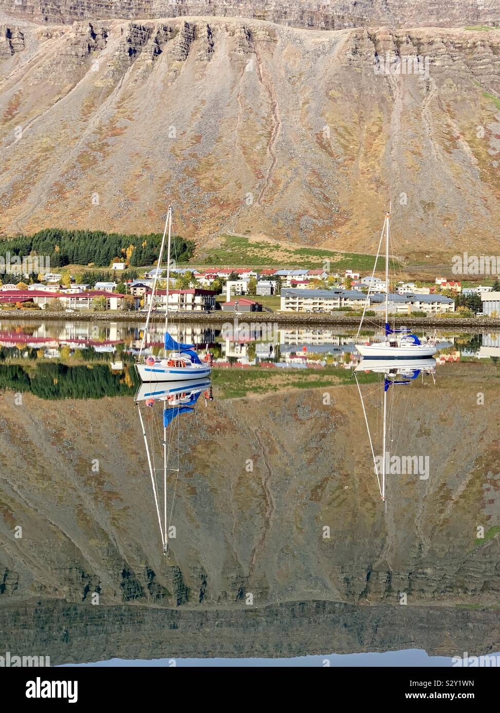 Isafjordur, Islanda - Settembre 2019: bellissimi riflessi nell'acqua ancora di questo porto nei Fiordi Occidentali. Foto Stock
