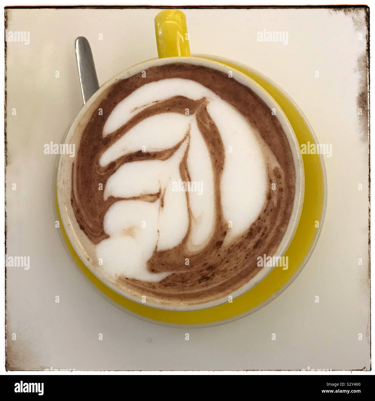Latte Art sul caffè in tazza di colore giallo. Foto Stock