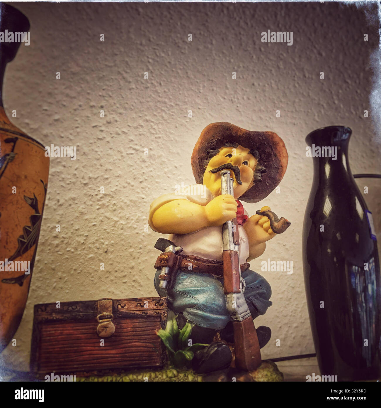 Figurina di un cowboy con una pistola per la sua bocca, visto in un negozio di carità nel nord di Londra. - Immagine stock catturata con smartphone