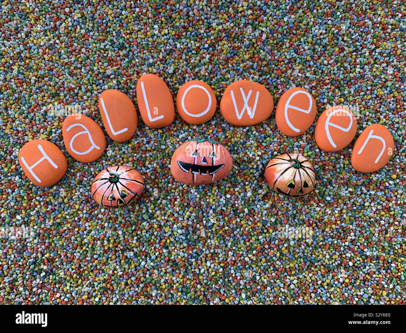 Testo di Halloween composta con colore arancione lettere di pietra con la pietra di zucche su ghiaia multicolore - Immagine stock catturata con smartphone