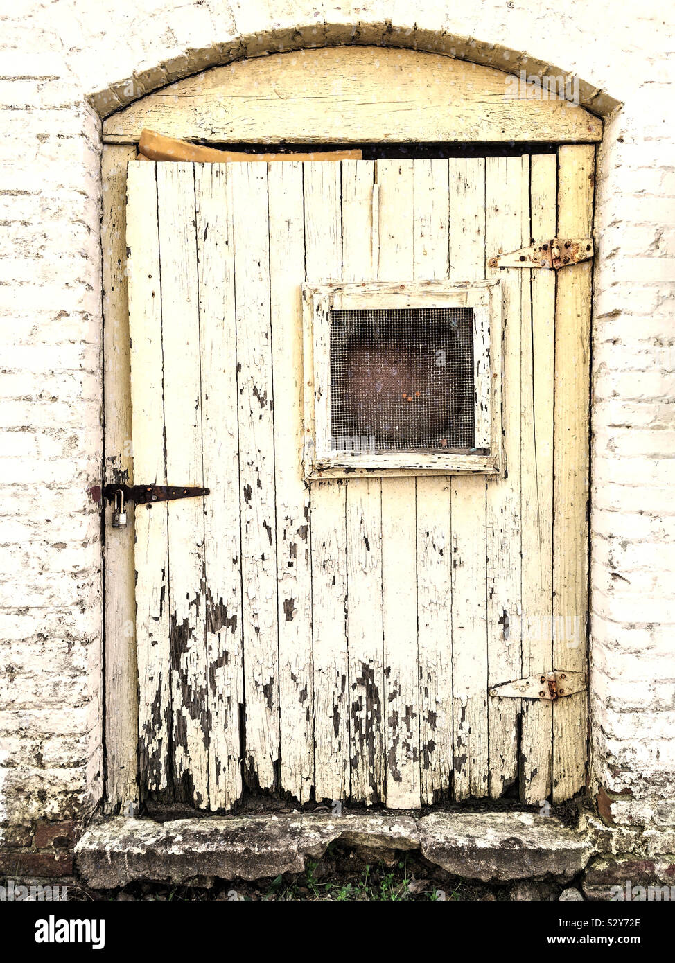 Un vecchio edificio abbandonato con una porta di legno che si sta deteriorando con l'età. Foto Stock