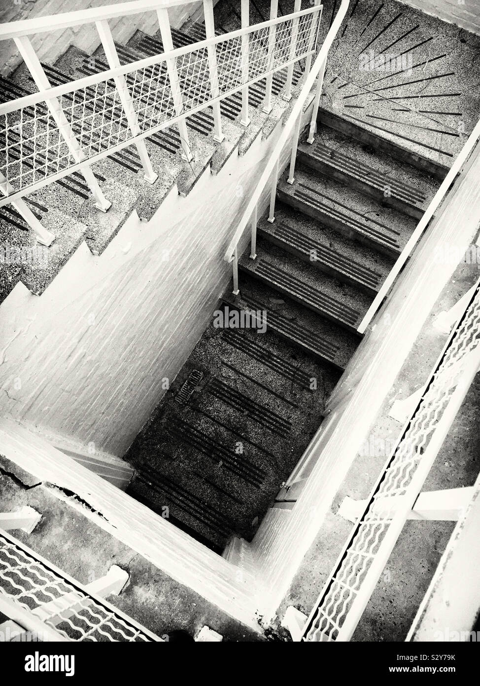 Il punto di vista di alta angolazione di una rampa di scale in una storica casa in bianco e nero. Foto Stock