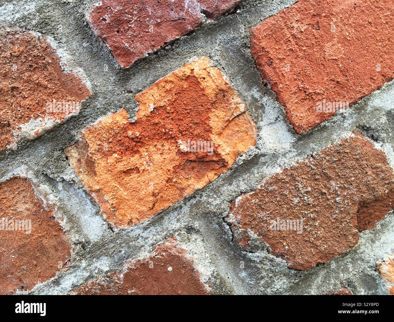 Un edificio storico costruito di grandi dimensioni e di colore rosso mattone con malta cementizia tenendolo insieme. Questa macro shot mostra tutti i dettagli e le texture. Foto Stock