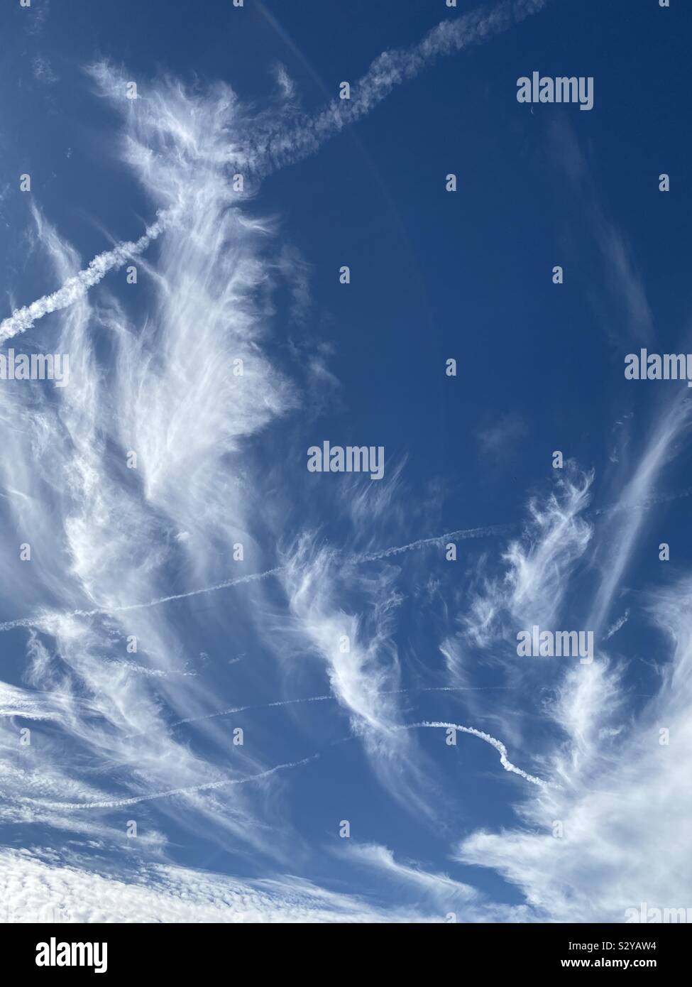 Bianco di vorticazione feathery nuvole con cieli blu - Immagine stock catturata con smartphone