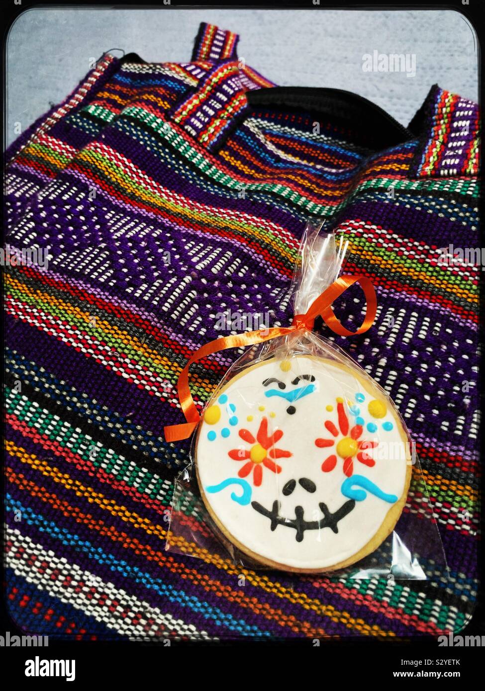 Un cookie avvolto è decorato per il Día de los Muertos e viene visualizzata su un colorato portamonete. Foto Stock