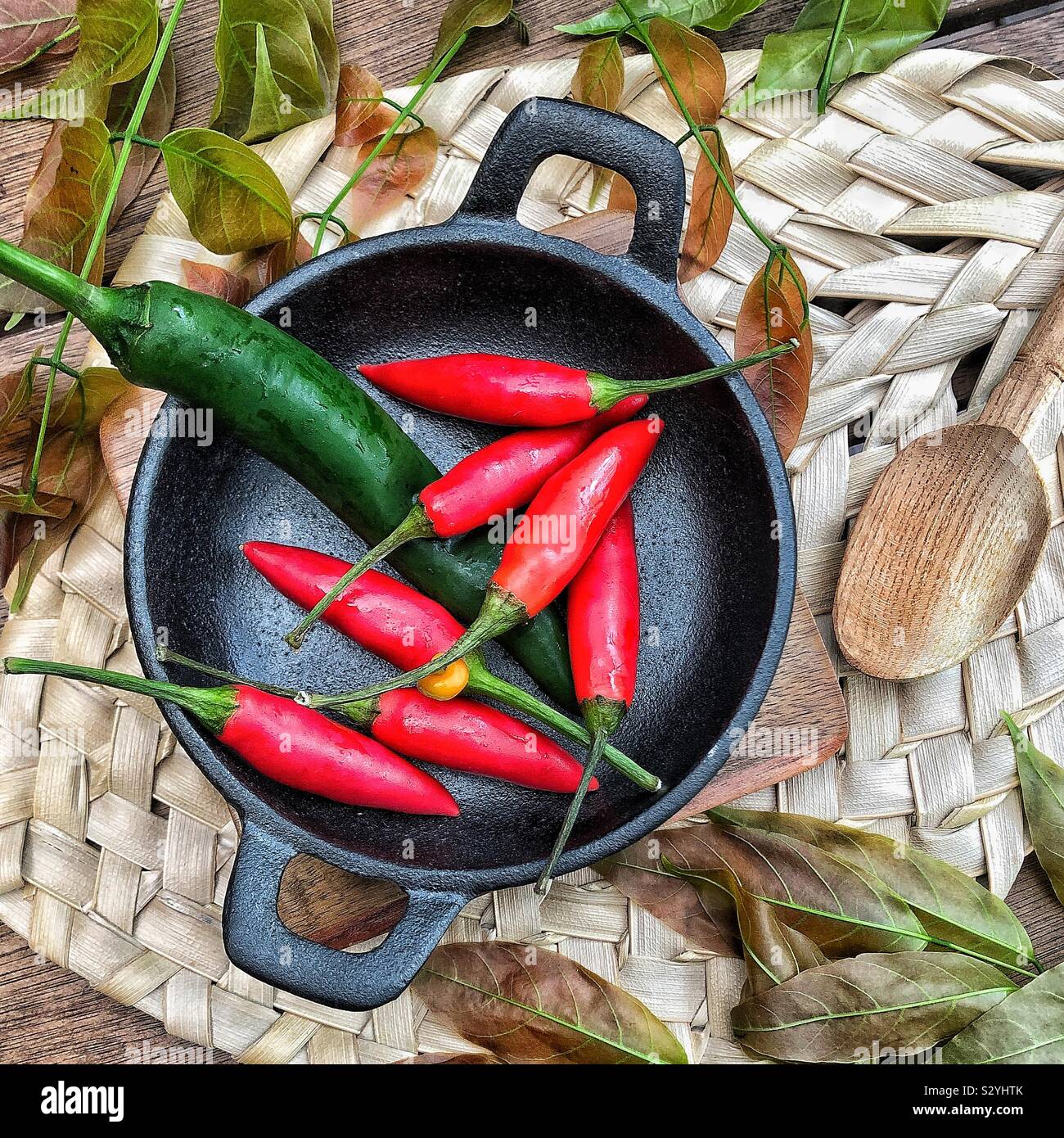 Cibo rosso e verde in ciotola di ghisa nera piatto piccante - Immagine stock catturata con smartphone
