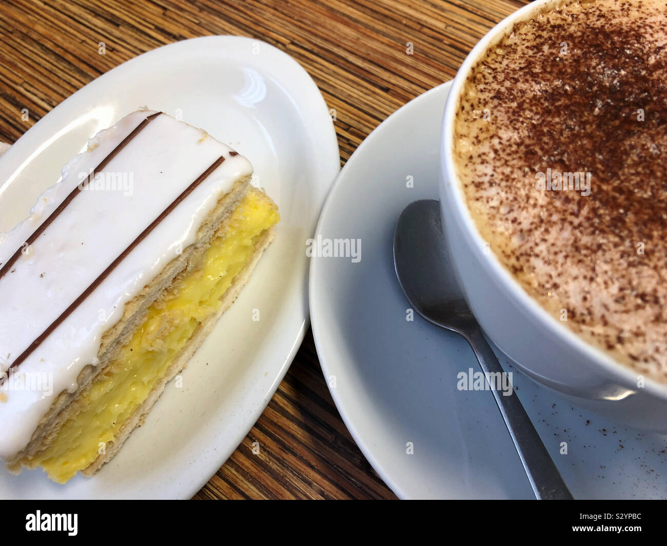 Una fetta di crema e un cappuccino - Immagine stock catturata con smartphone