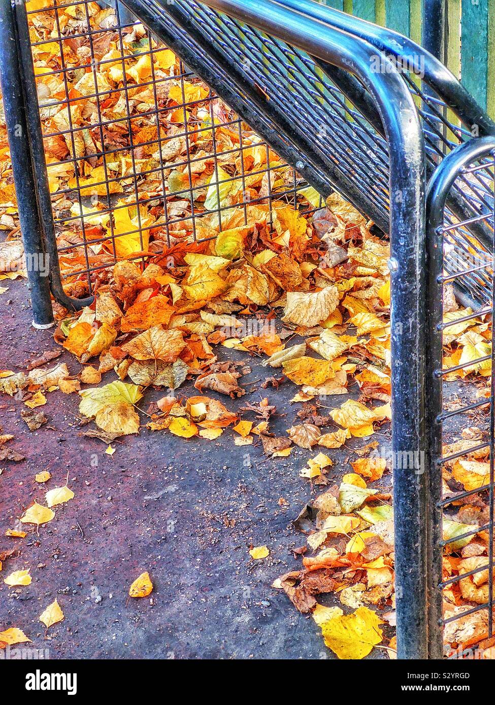 Obiettivo di metallo in un campo giochi per bambini piena di foglie di autunno - Immagine stock catturata con smartphone