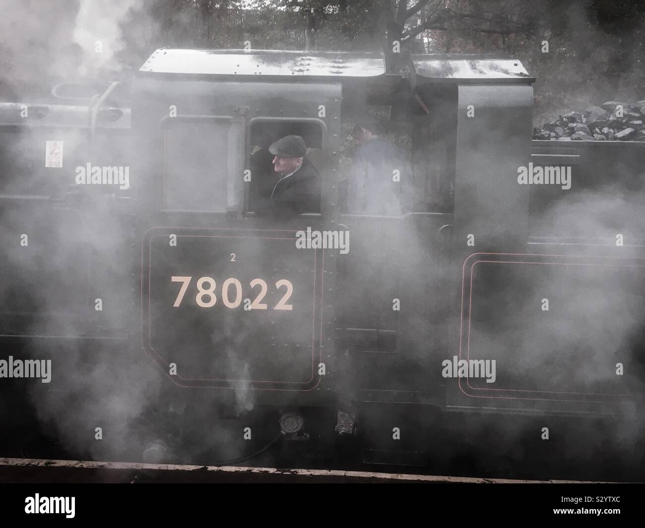 Driver del motore a Keighley e Worth Valley Railway circondata da vapore prima che il primo servizio della giornata. Foto Stock