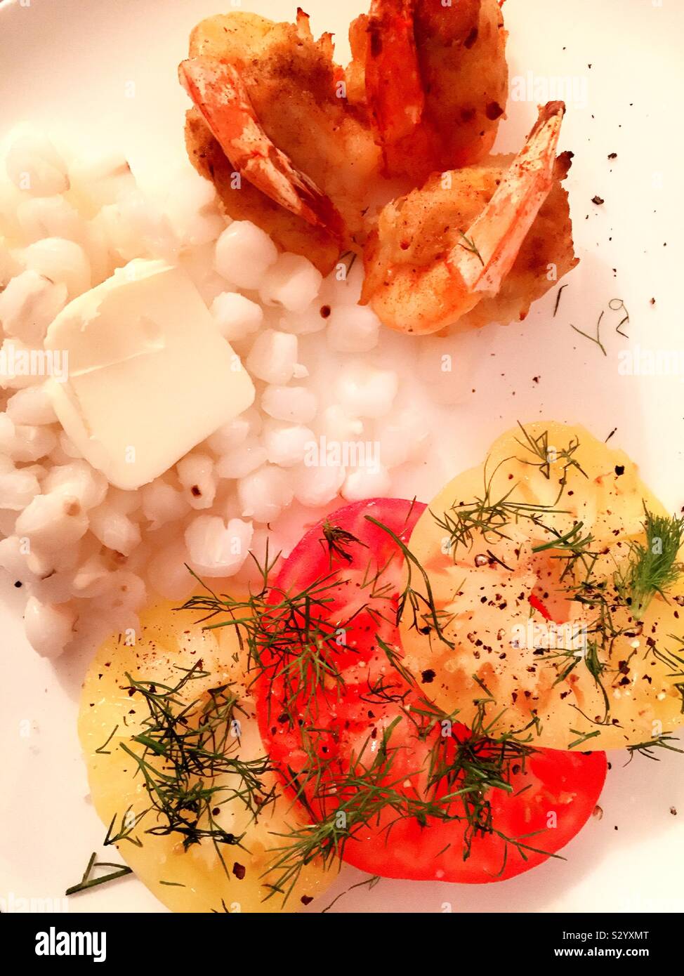 Piatto di laici un pasto equilibrato di gamberetti, hominy e affettato cimelio di pomodori Foto Stock