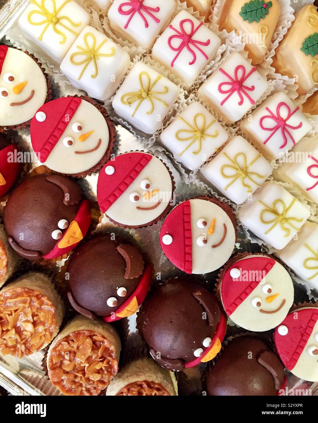 Guardando verso il basso a partire da sopra su una varietà di deliziosi dolci e fantasie fondente in una pasticceria francese che sono decorate con decorazioni natalizie e spazio di copia Foto Stock
