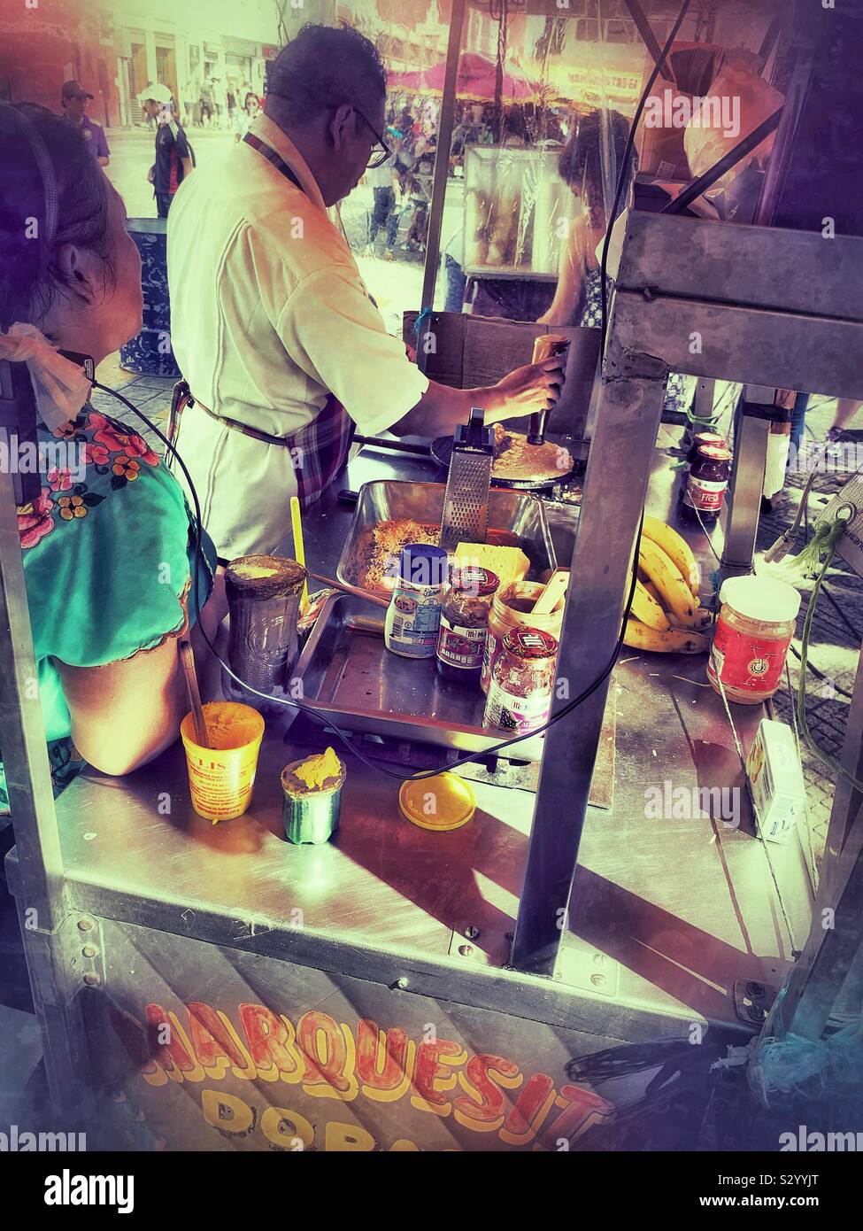 Un venditore ambulante prepara un Marquesita riempiendolo con cajeta e formaggio Edam prima di arrotolamento della crêpe croccante come il popolare snack alimentare a Mérida. Foto Stock