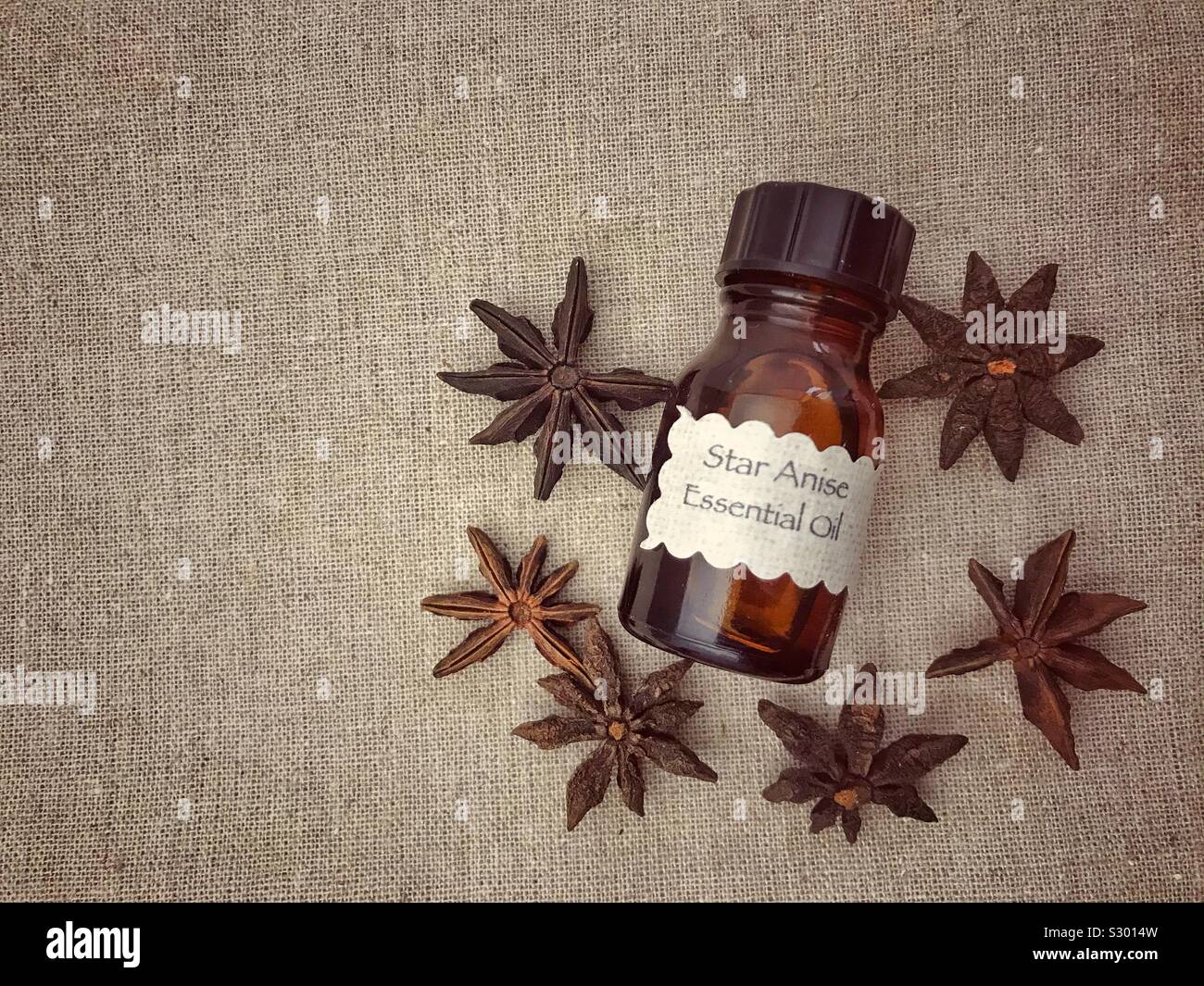 Bottiglia di Olio essenziale e di anice stellato su un sfondo di lino con copia spazio. - Immagine stock catturata con smartphone