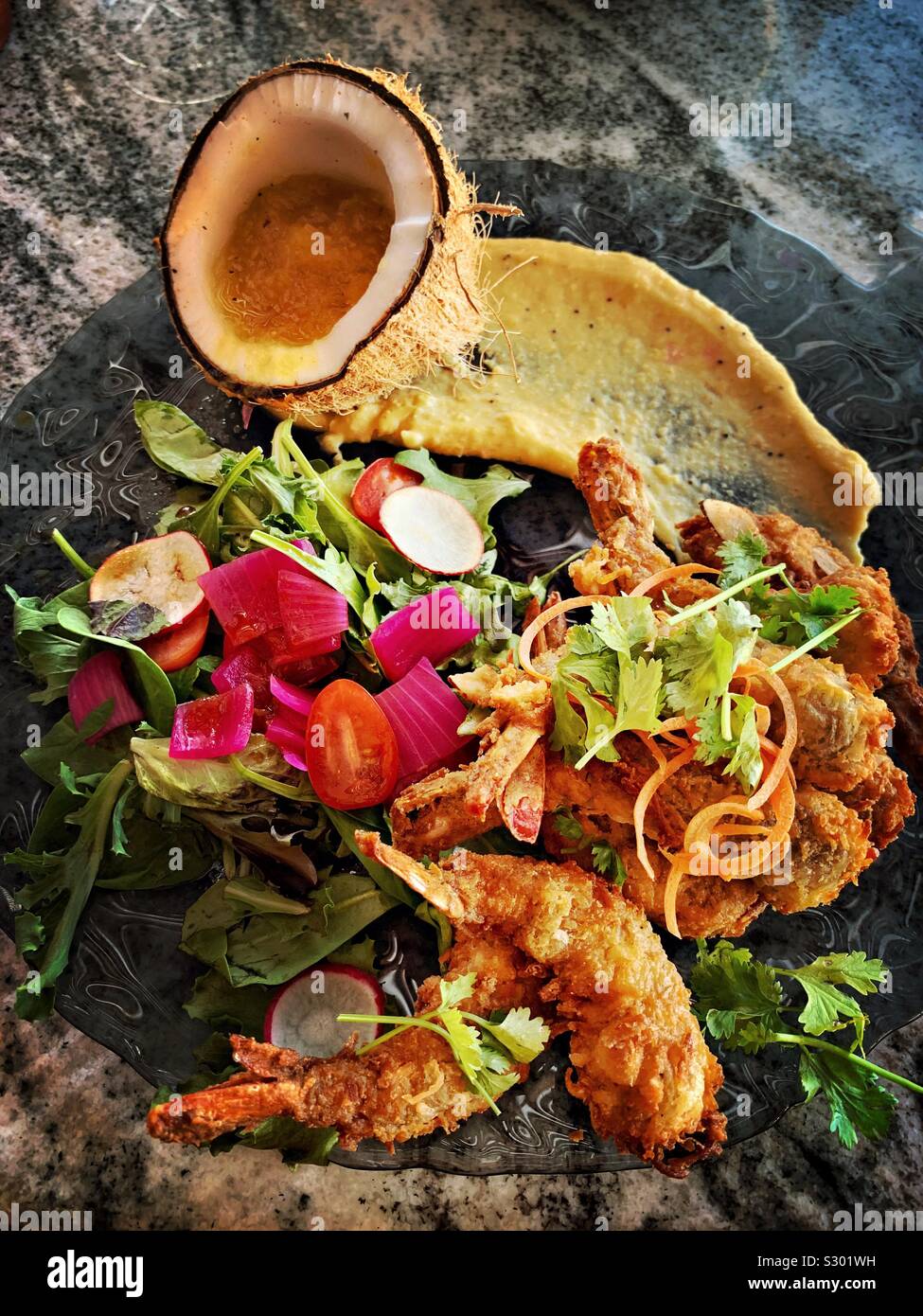 Una bella presentazione di gamberi in salsa di cocco viene servita presso il ristorante sulla spiaggia Crabster in Progreso. Foto Stock