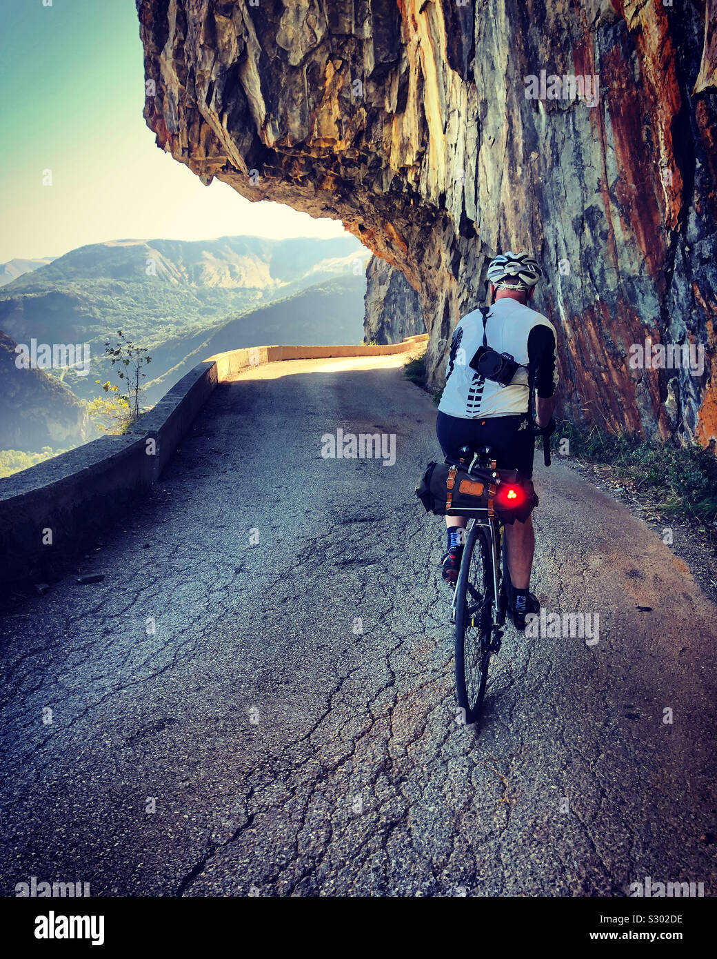 Ciclista maschio salendo la strada balcone da Bourg d'Oisans a Villard Notre Dame, sulle alpi francesi. Foto Stock