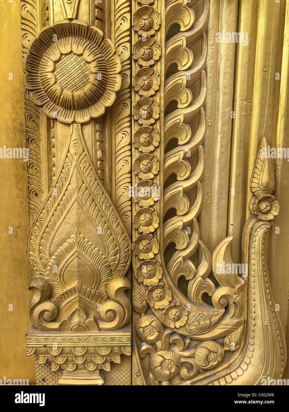 Ornate design decorativo su un oro dipinta porta di legno. - Immagine stock catturata con smartphone