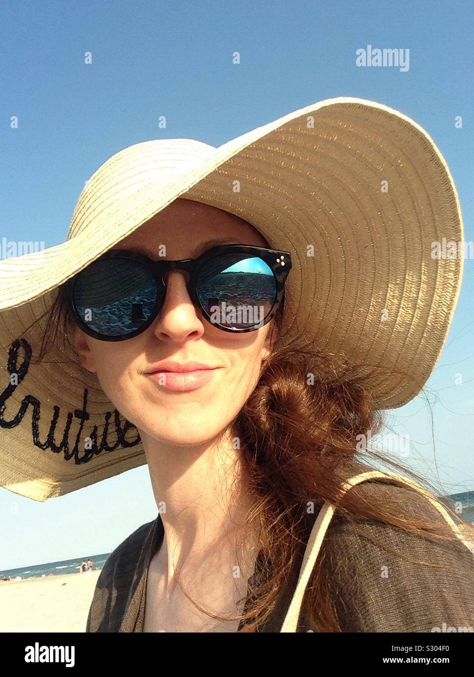 Donna che indossa grande spiaggia hat. Foto Stock