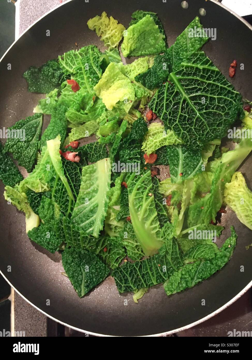 Una sana cucina casalinga. Deliziosa la verza con pancetta nessun grasso nella pentola. Willesden Green, Londra, Regno Unito - Immagine stock catturata con smartphone