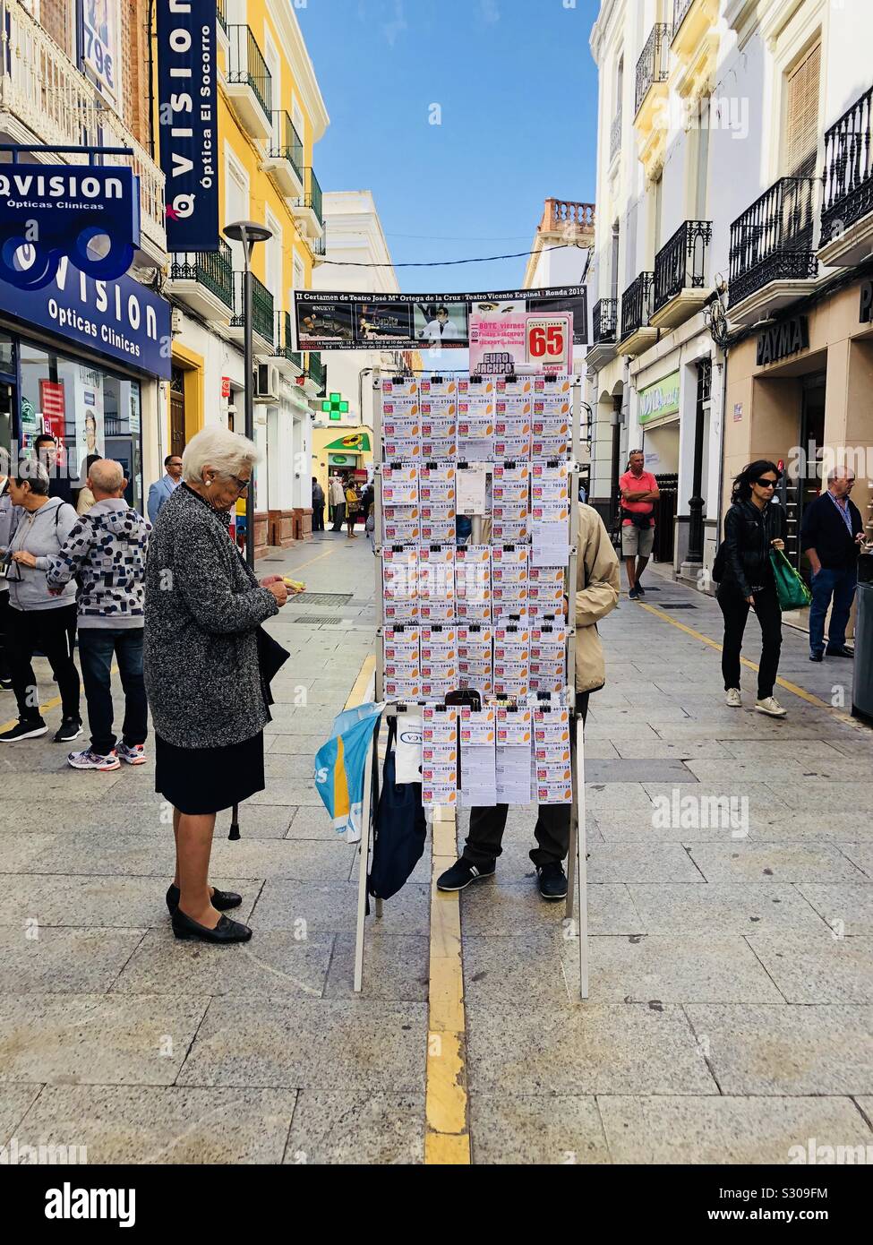 Old Lady di acquistare un biglietto della lotteria da un venditore ambulante in Spagna Foto Stock