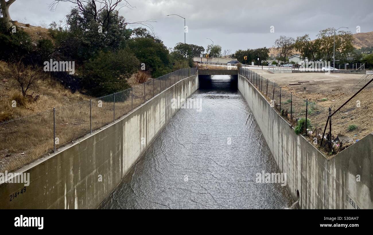 Flussi di acqua attraverso l'uomo fatto calcestruzzo canale creato per il fiume di Los Angeles in un giorno nuvoloso - Immagine stock catturata con smartphone