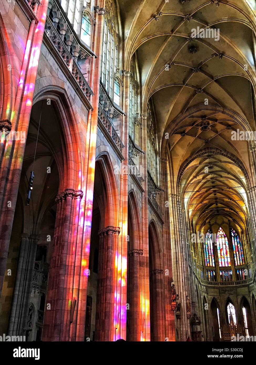 I colori da colorato mosaico di vetro riflettendo sui pilastri all'interno della Cattedrale di San Vito, Praga, Repubblica Ceca Foto Stock