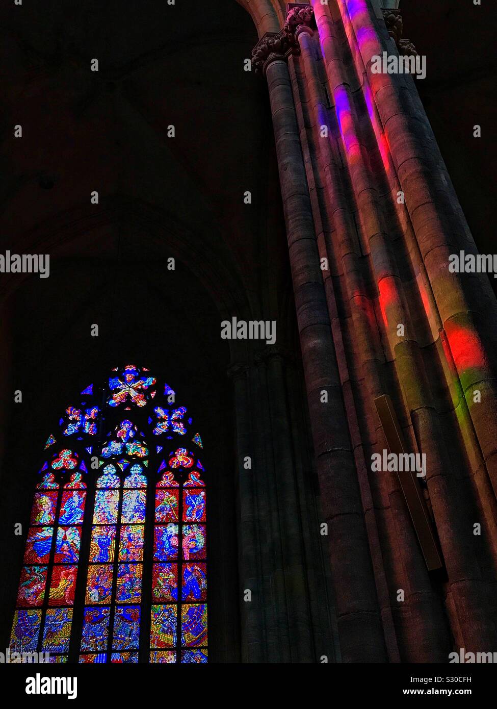Vetro colorato e colori che riflettono su un pilastro presso la Cattedrale di San Vito, Praga, Repubblica Ceca, Europa Foto Stock