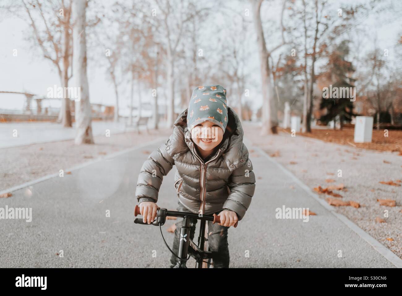 Capretto felice sulla bici Foto Stock