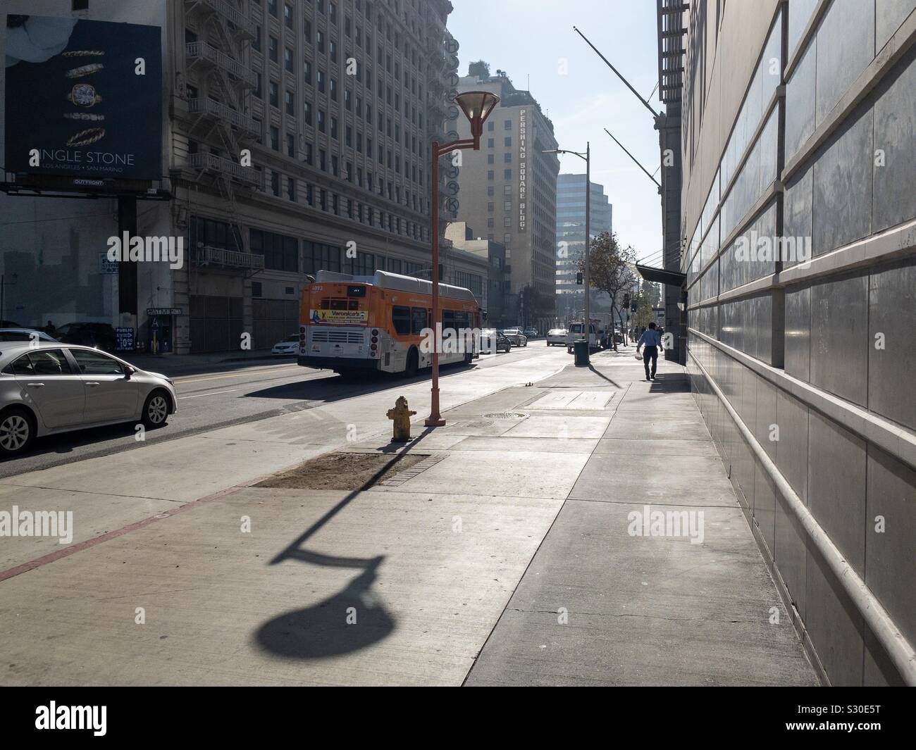 LOS ANGELES, CA, NOV 2019: vista la mattina con lunghe ombre lungo Hill Street nel centro cittadino. La gente camminare, la metropolitana e bus il traffico che passa. Foto Stock