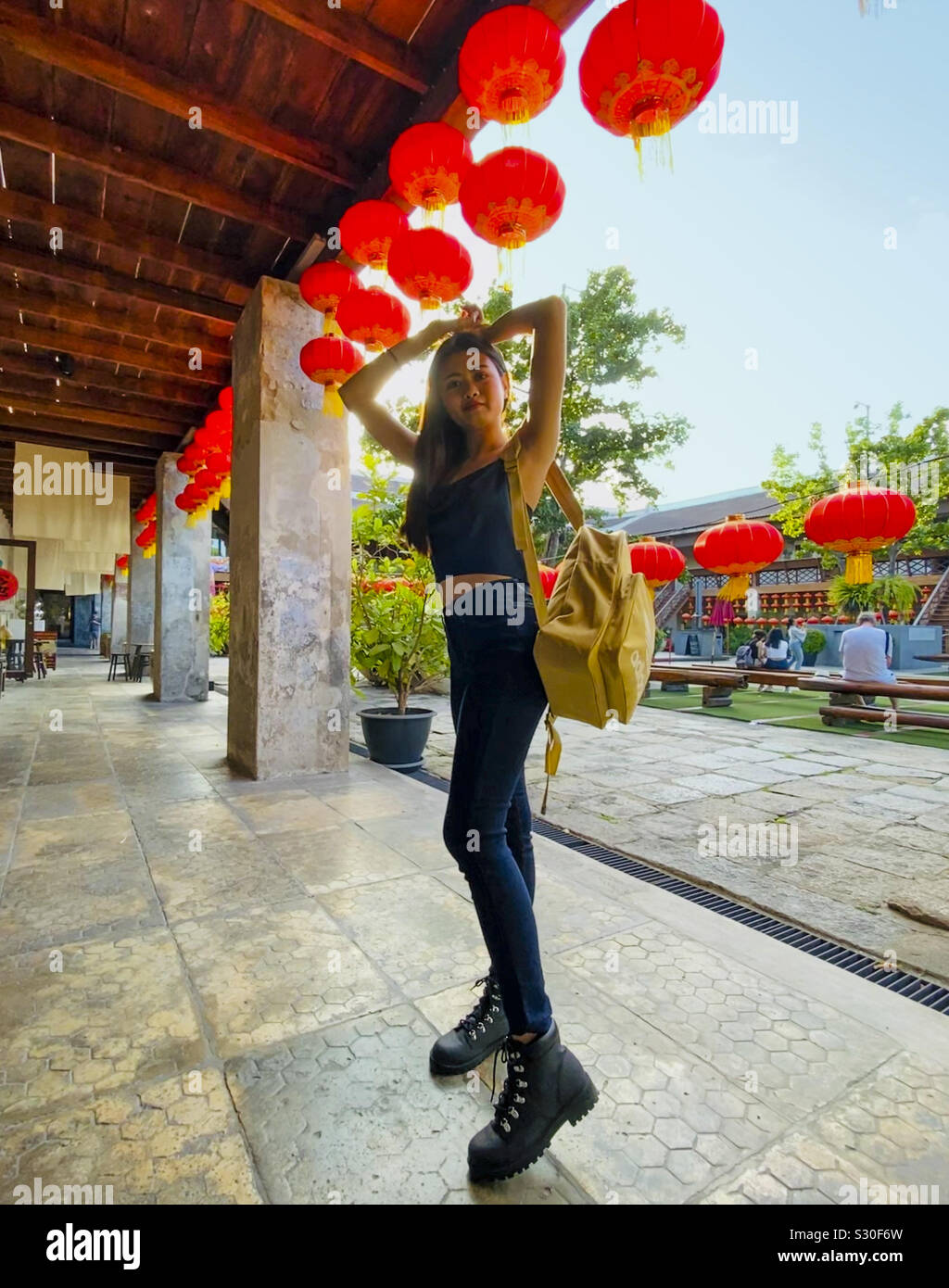 Bella ragazza asiatica pone sotto lanterne rosse Foto Stock