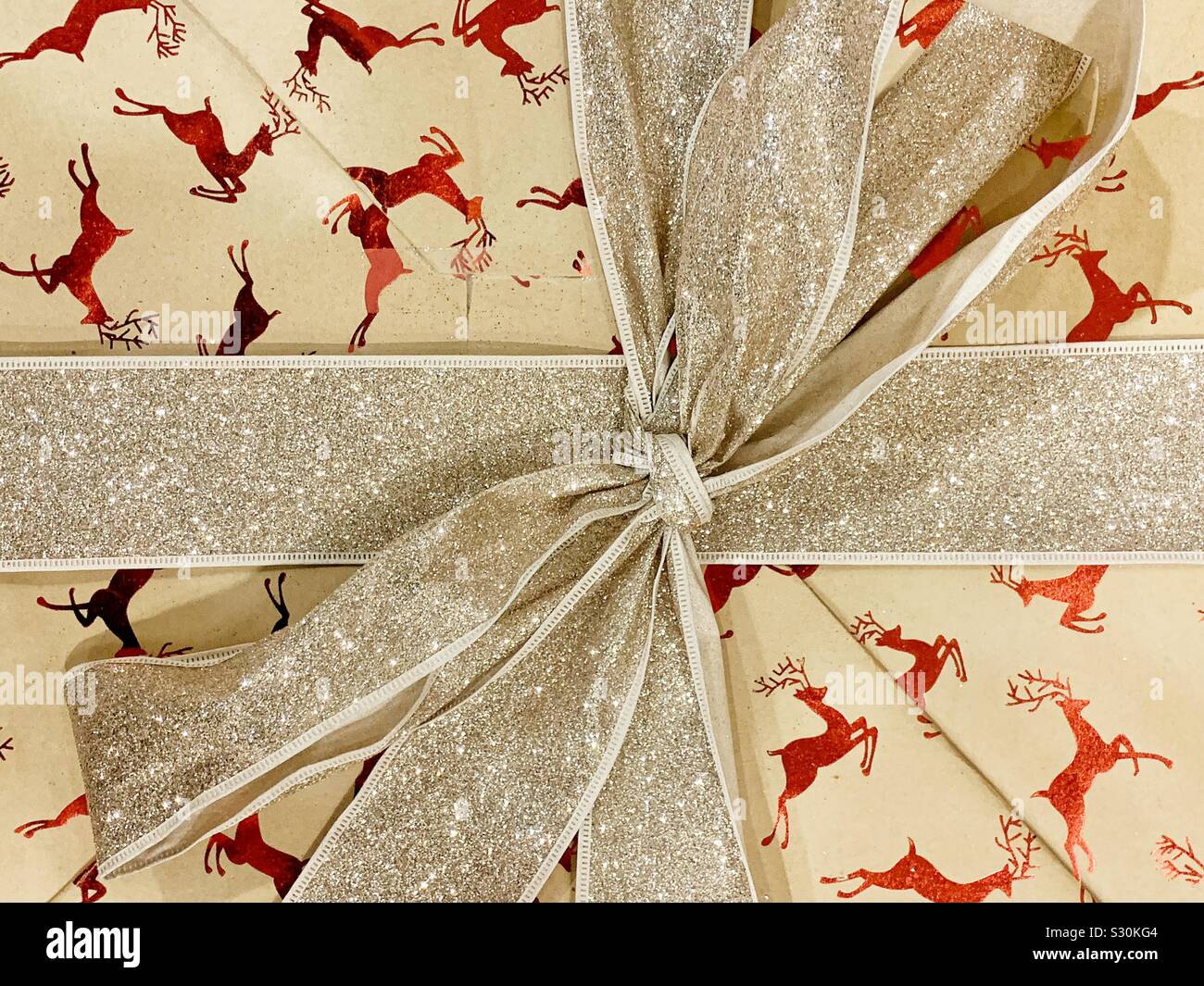 Gift Wrapped box con motivo di renne e oro nastro scintillanti Foto Stock