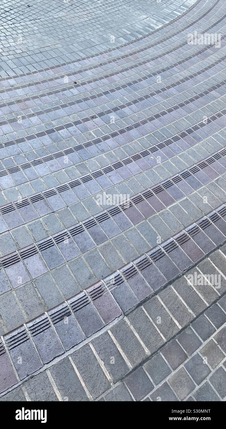 Dettaglio di mattoni in un incurvamento outdoor plaza e passaggi pedonali, creazione astratta di texture di sfondo Foto Stock