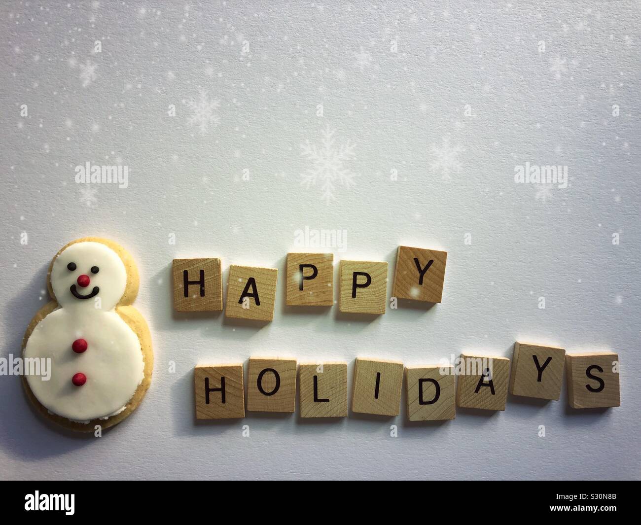 Buone vacanze e gingerbread pupazzo di neve con i fiocchi di neve e spazio di copia - Immagine stock catturata con smartphone