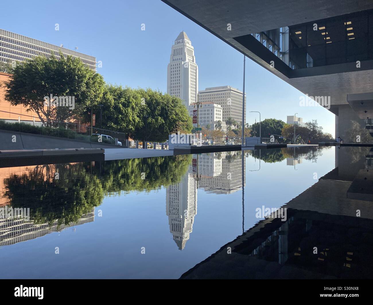 LOS ANGELES, CA, NOV 2019: Municipio visto da di fronte piscina riflettente al di fuori del tribunale federale edificio nel centro di centro civico Foto Stock