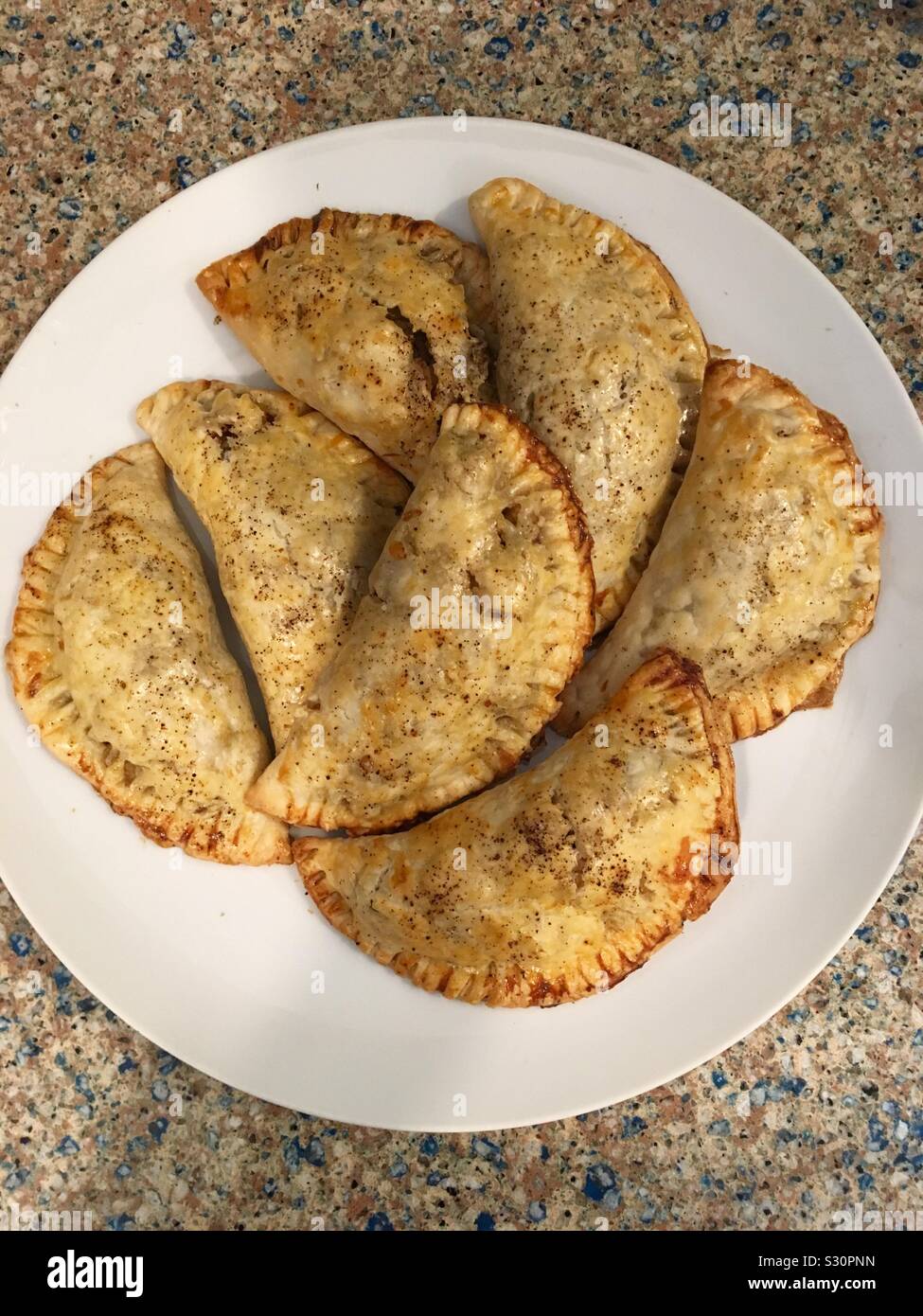 Pane appena sfornato le empanadas su una piastra. - Immagine stock catturata con smartphone