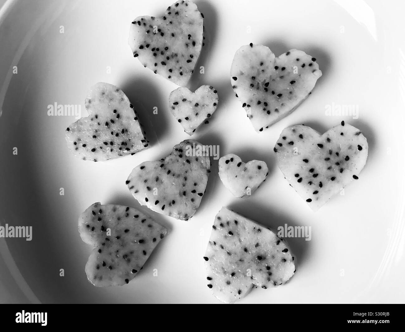 Dragon frutto in colore bianco ,taglio simili a forma di cuore in bianco piastra in ceramica Foto Stock