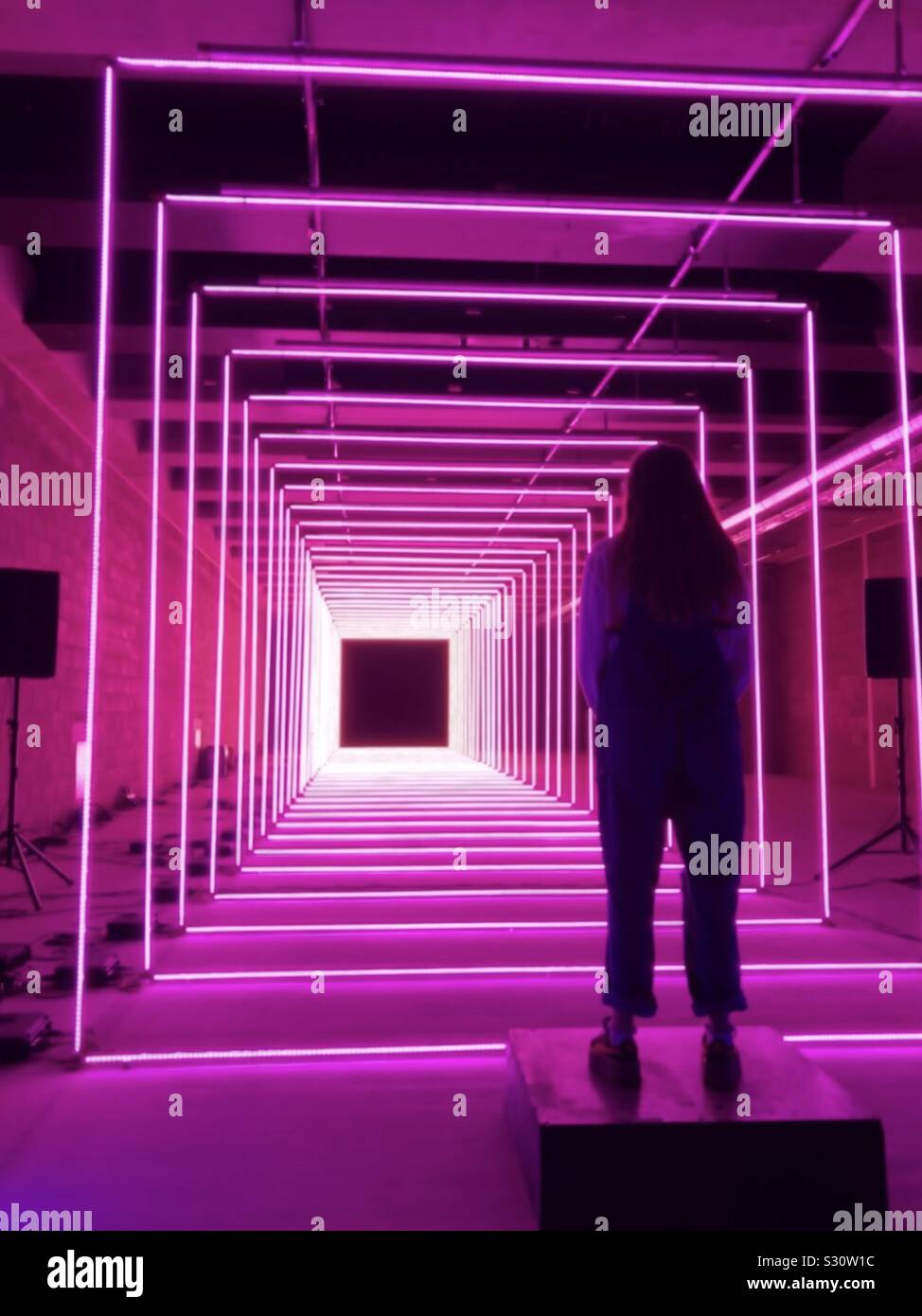 Mya in piedi da una installazione al neon in inverno luci, London, 2018 Foto Stock