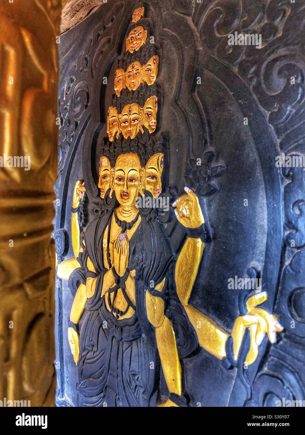 Facce di Buddha dipinta su una ruota di preghiera in un monastero del Bhutan. - Immagine stock catturata con smartphone