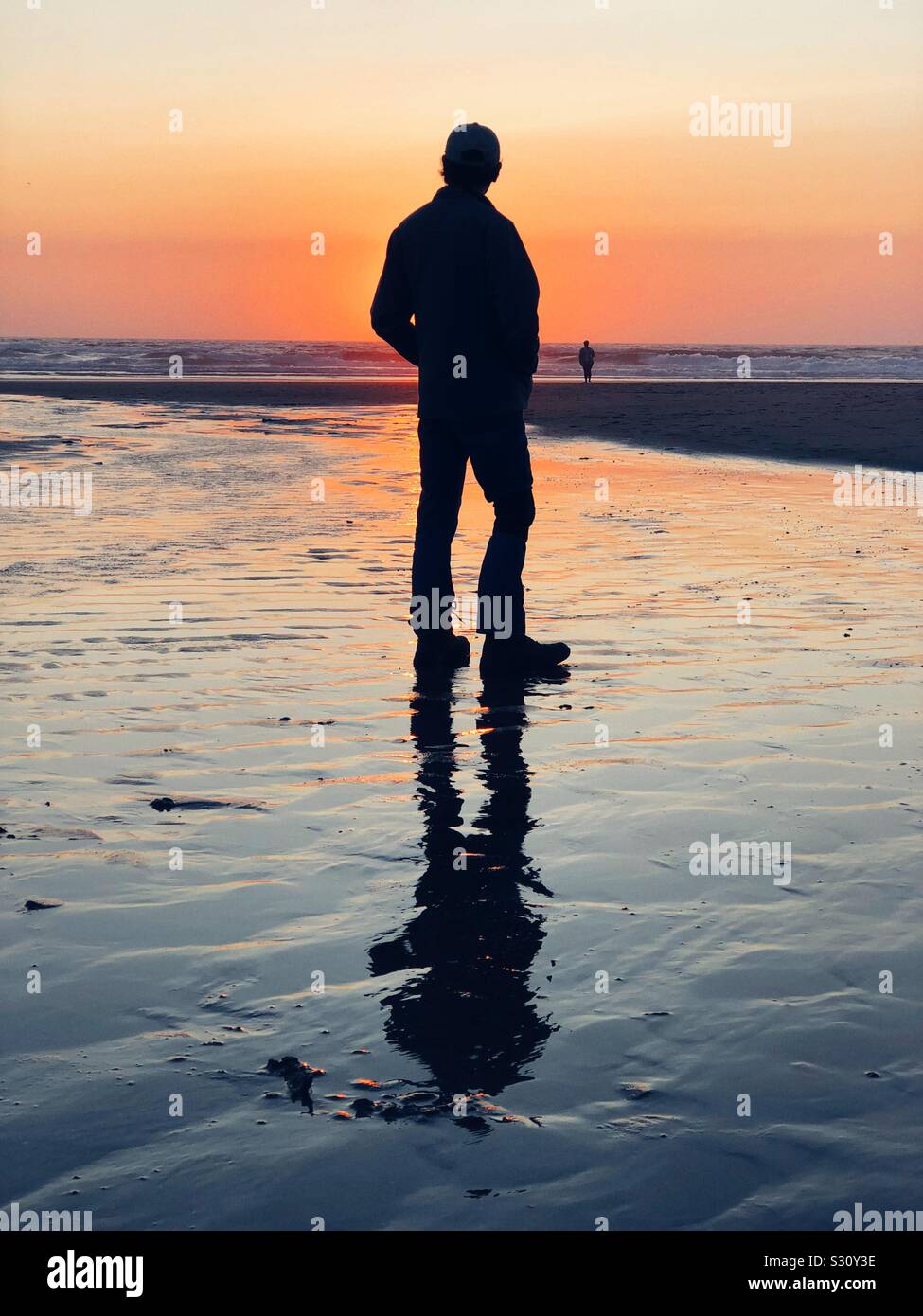 Silhouette se un uomo al tramonto su una spiaggia a Lincoln City Oregon Foto Stock