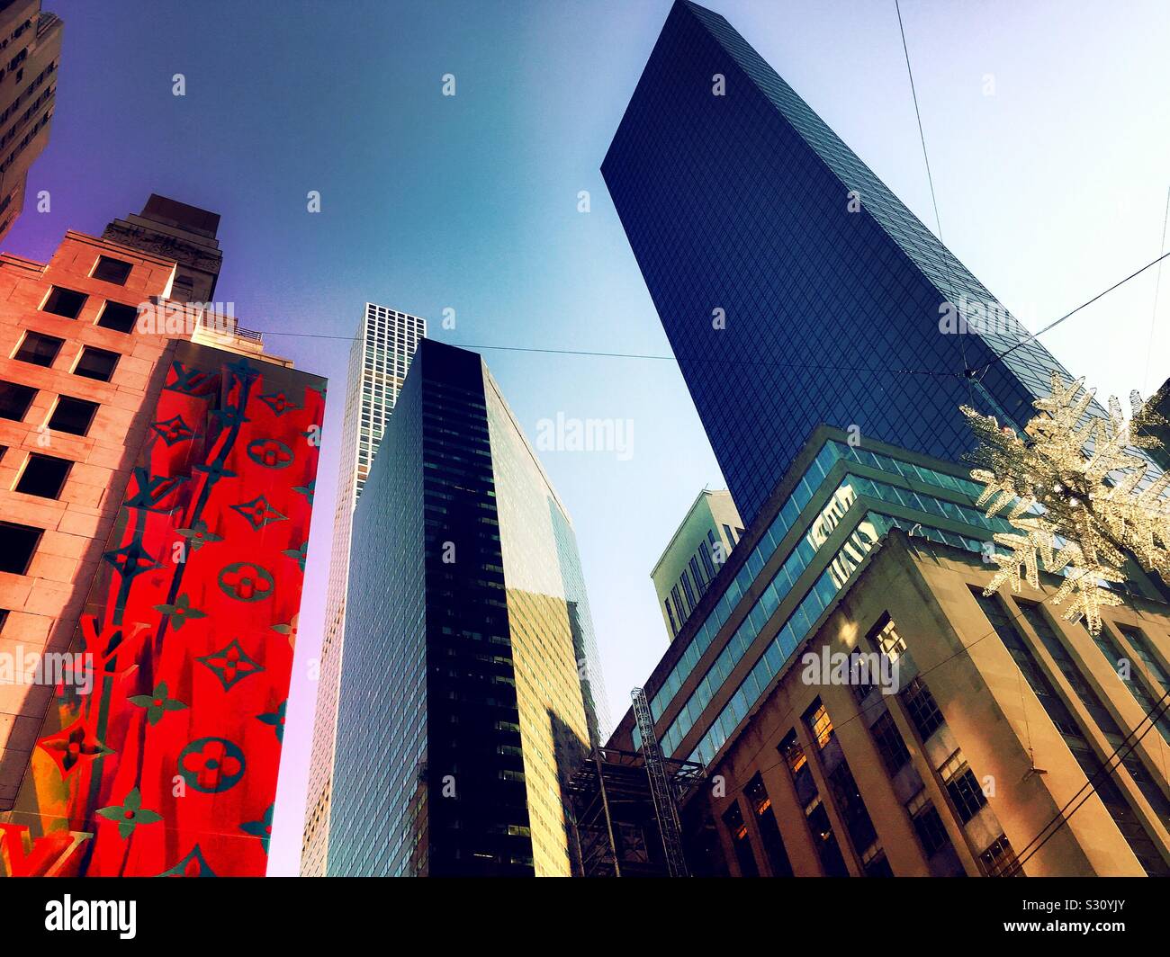 I grattacieli lungo la quinta Avenue hanno un'illuminazione festiva durante la stagione natalizia, NYC, USA - Immagine stock catturata con smartphone