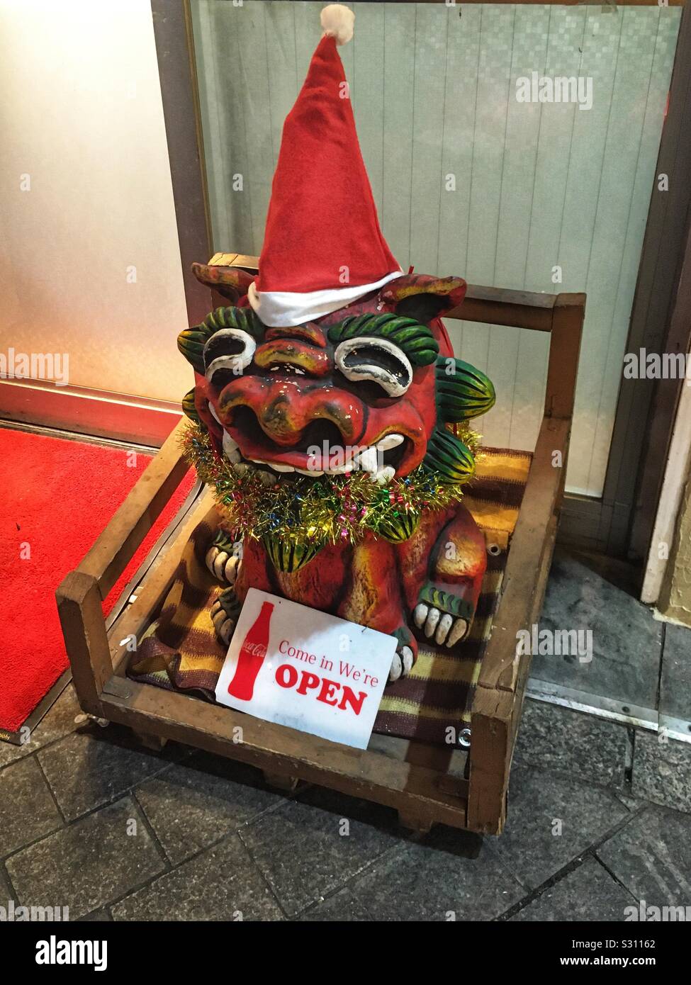 Shiisa Okinawa lion cane in abito di Natale di fronte ad un ristorante a Tokyo Foto Stock