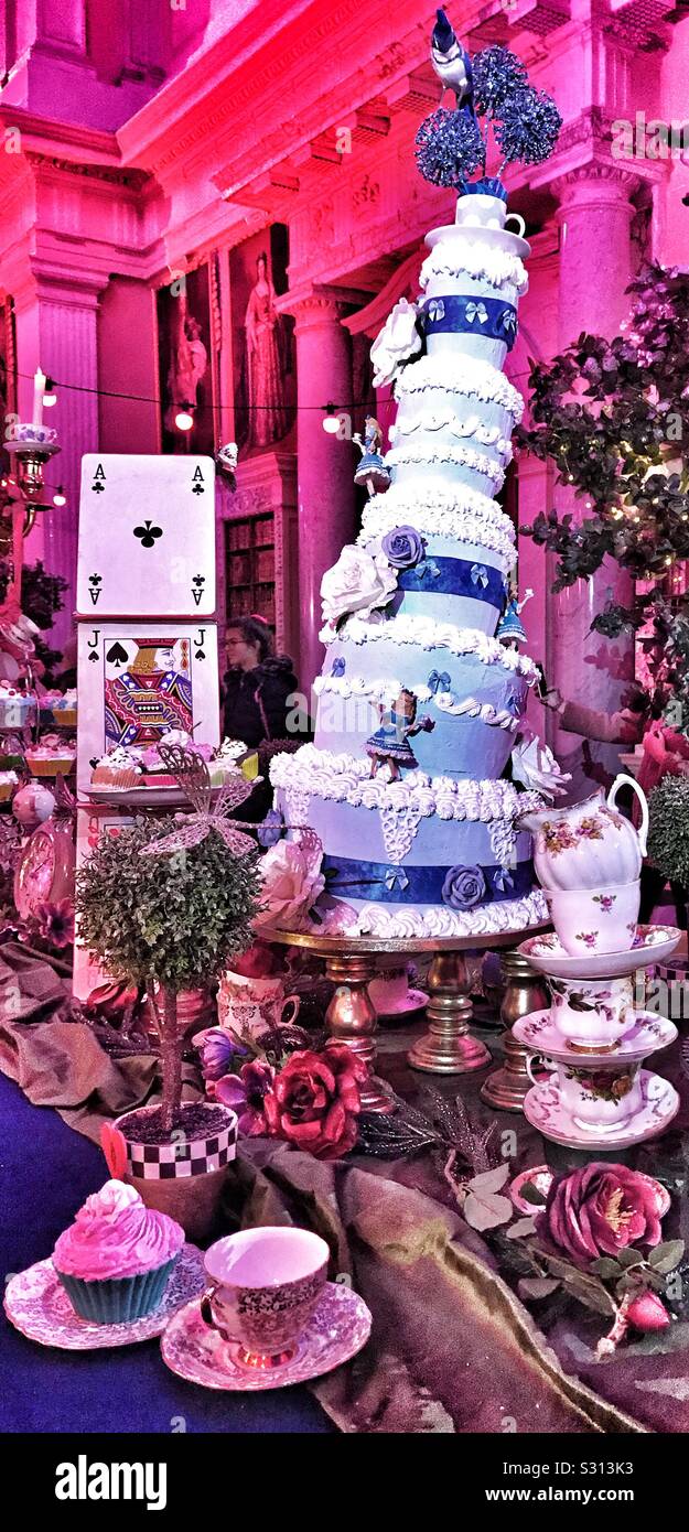 Alice nel Palazzo di Blenheim Palace il Natale 2019 - Il Mad Hatters Tea Party tabella con una Wonky Tiered Cake ghiacciato in blu con Alice nel paese delle meraviglie su Foto Stock
