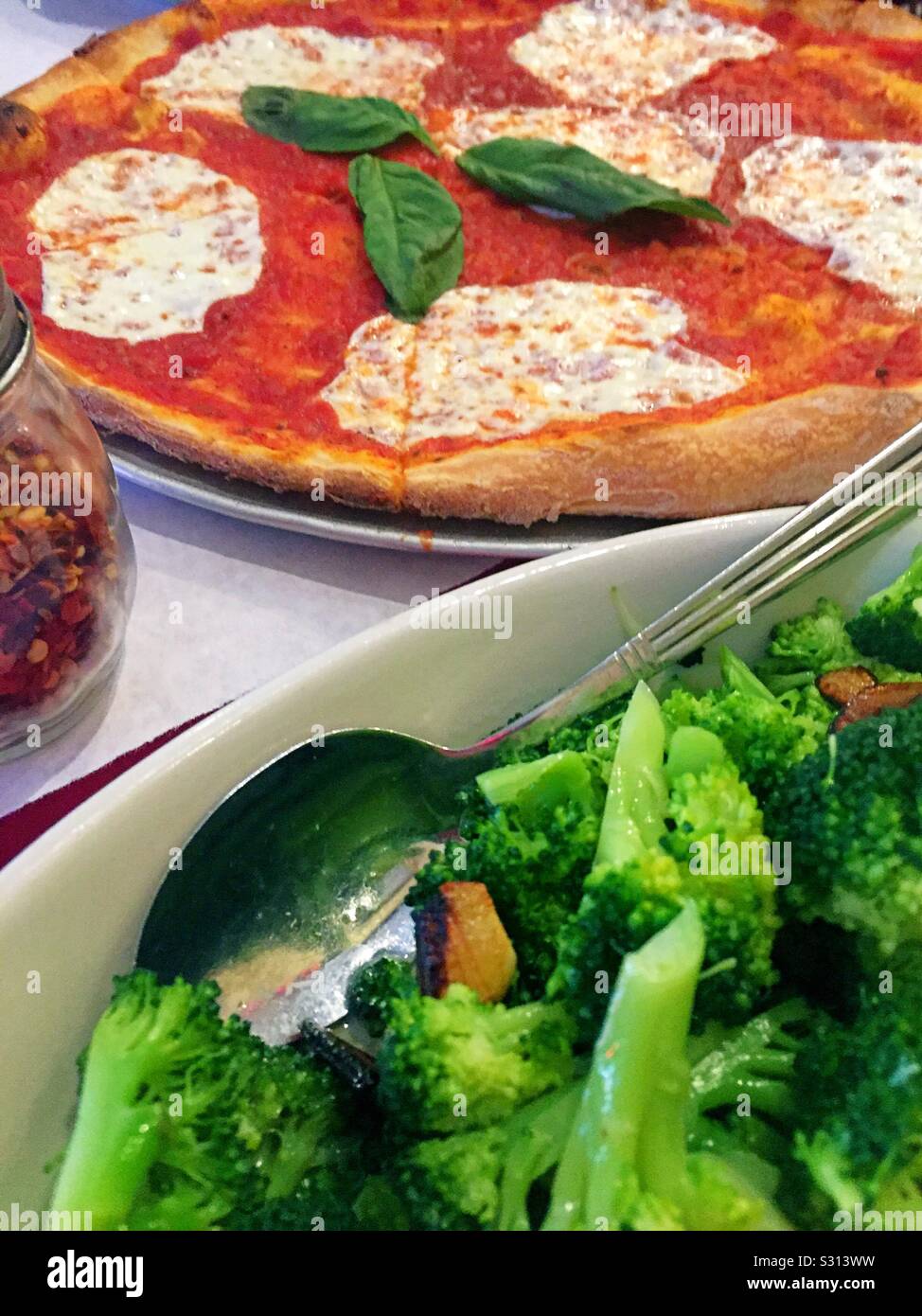 Pizza e broccoli pasto presso un ristorante italiano a Little Italy, NYC, USA - Immagine stock catturata con smartphone
