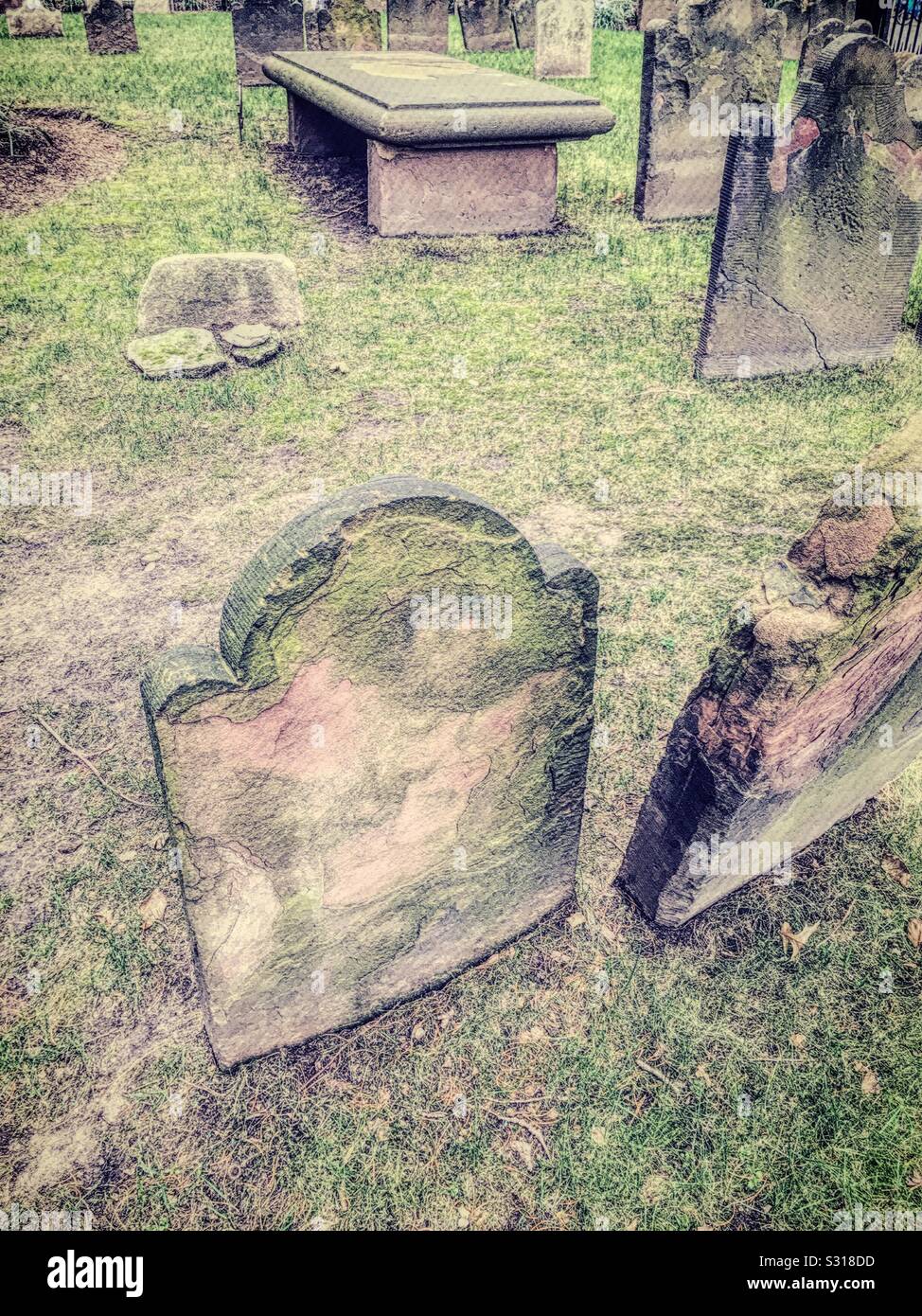 Lapidi indossate lisce nel tempo in antico cimitero storico Foto Stock