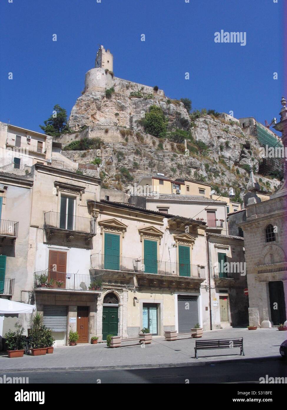 Fortificata medioevale edificio su una scogliera al di sopra di una cittadina siciliana Foto Stock