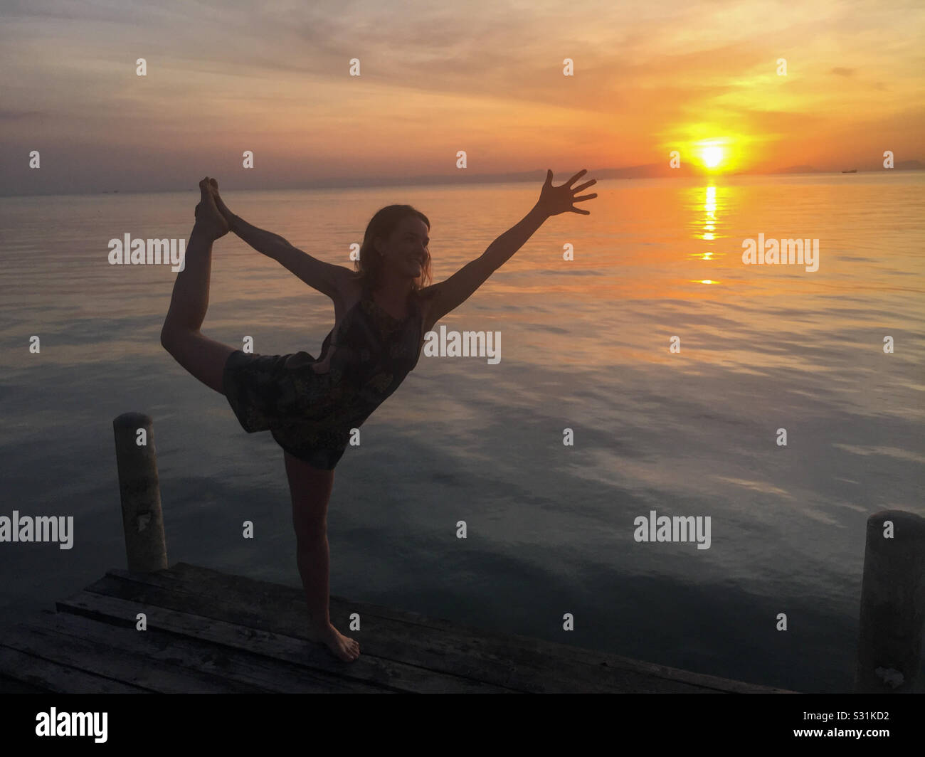 Ballerina al tramonto. Una giovane donna fa esercizio di danza nel tramonto bagliore in Cambogia. Foto Stock