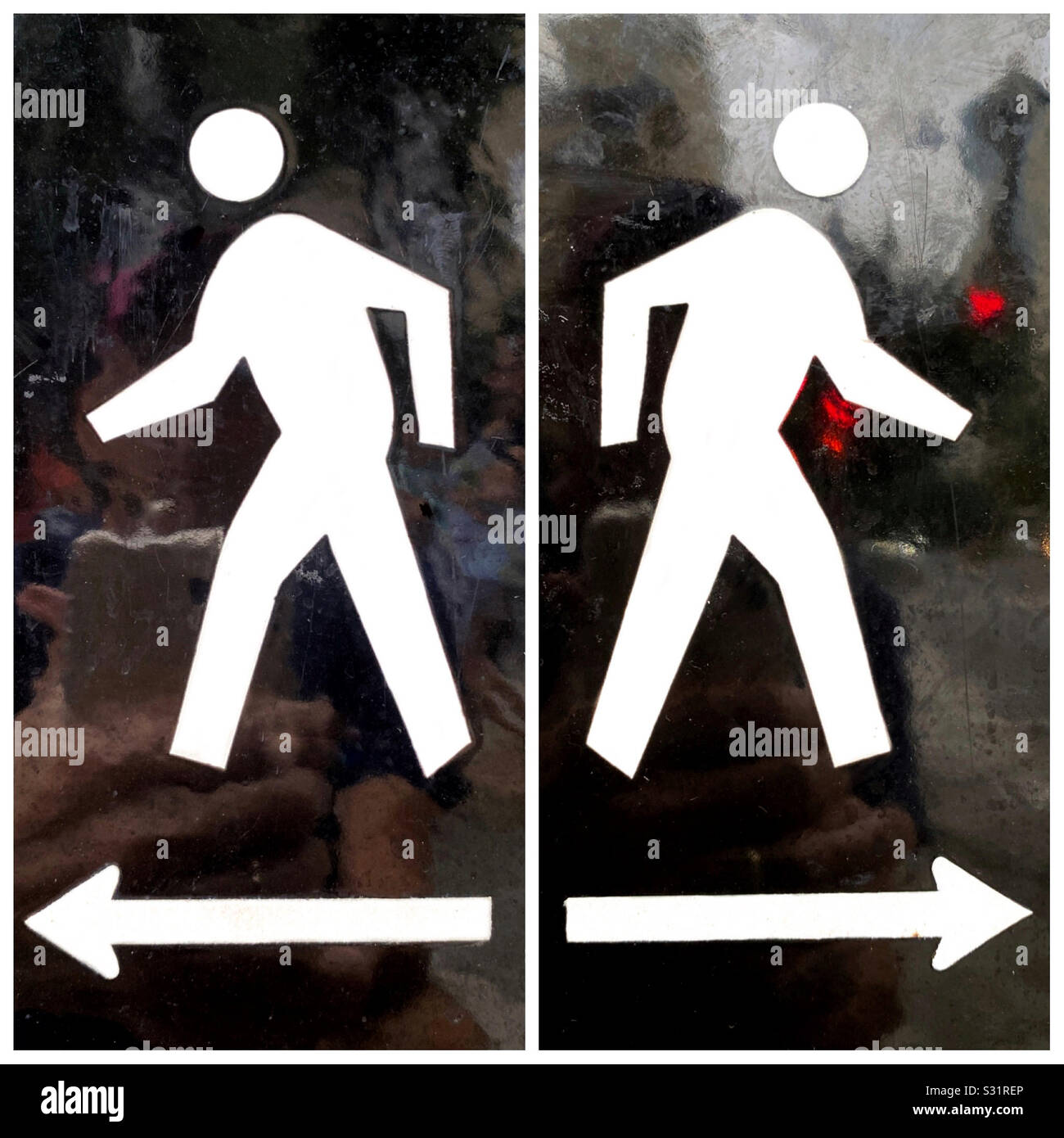 Due segni a piedi schiena a schiena con riflessioni offuscata dalla strada in background - Immagine stock catturata con smartphone