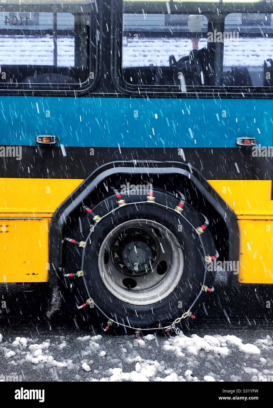 Autobus di città incatenato per la neve Foto Stock