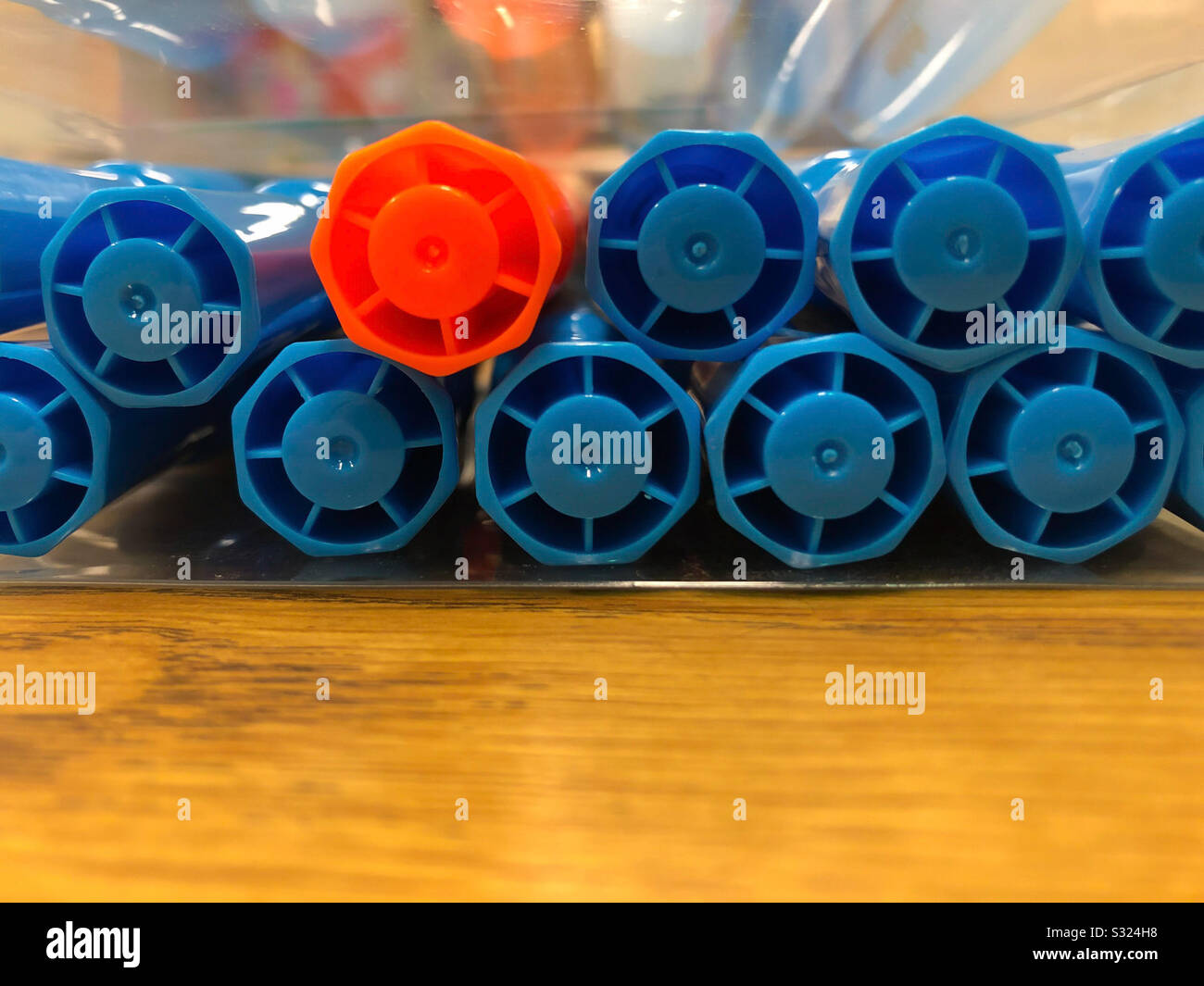 Diversi evidenziatori blu e arancione accatastati su una scrivania della scuola - Immagine stock catturata con smartphone