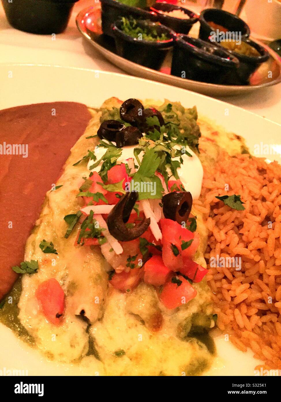 Appartamento Lay primo piano di un gourmet messicano entrée di enchiladas in un ristorante bianco tovlecloth, Stati Uniti Foto Stock